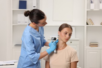 Photo of Doctor examining young woman's mole with dermatoscope in hospital