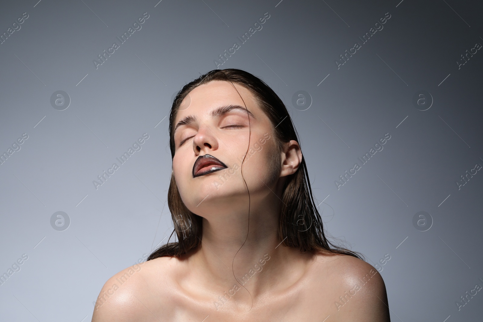 Photo of Beautiful young woman with black lip liner on light grey background