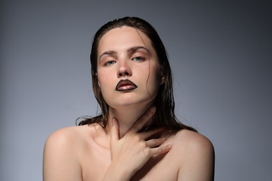 Photo of Beautiful young woman with black lip liner on light grey background