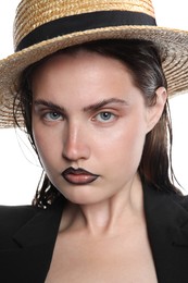 Photo of Beautiful young woman with black lip liner wearing straw hat on white background, closeup