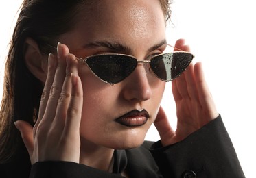 Photo of Beautiful young woman with black lip liner wearing wet sunglasses on white background, closeup
