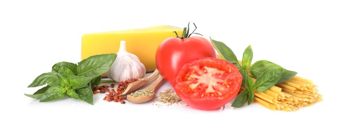 Photo of Raw spaghetti pasta and different ingredients isolated on white