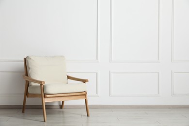 Photo of Comfortable armchair near white wall indoors, space for text