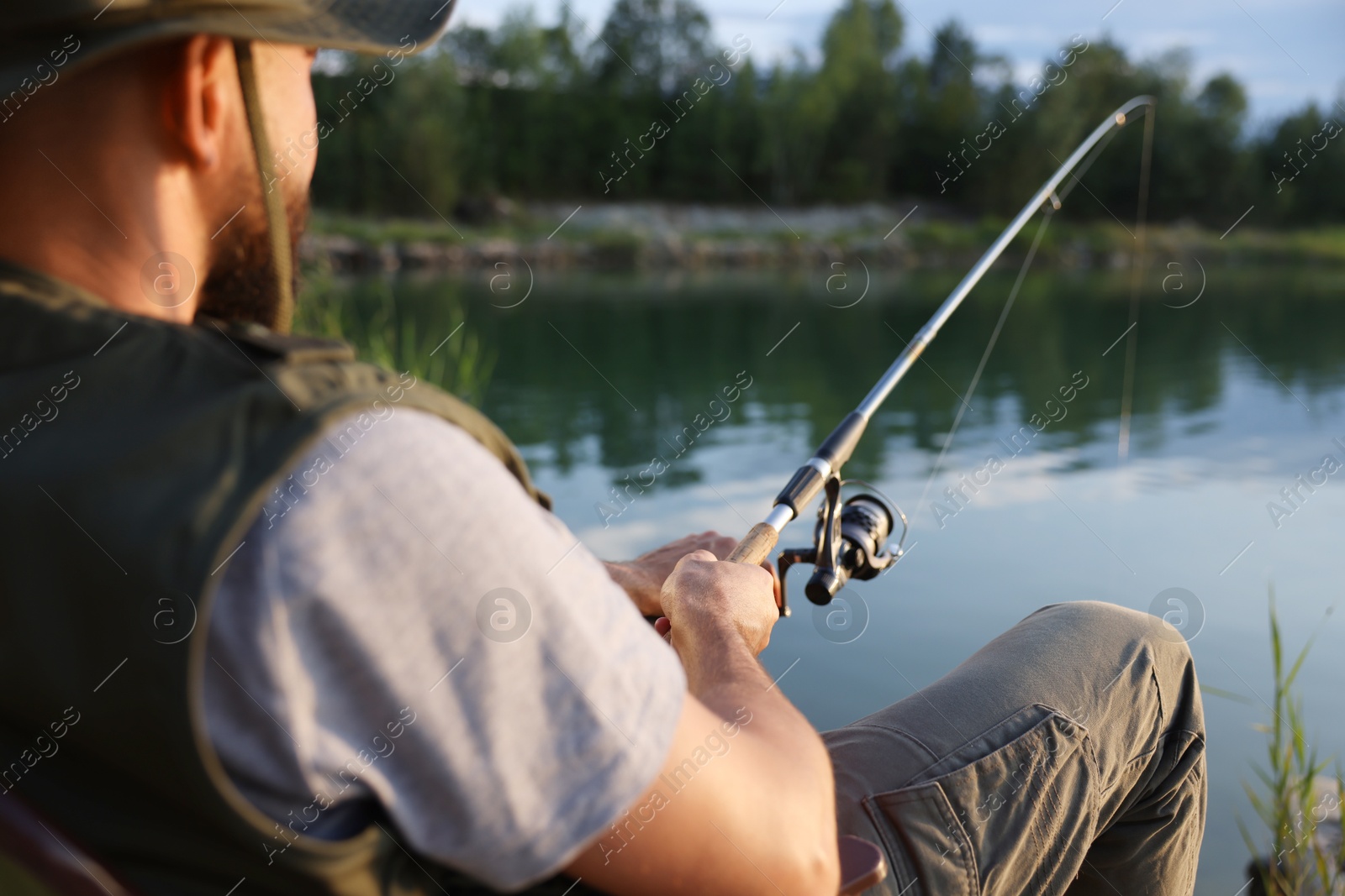 Fisherman with rod fishing near lake at summer, selective focus Photo of Fisherman with rod fishing near lake at summer, selective focus