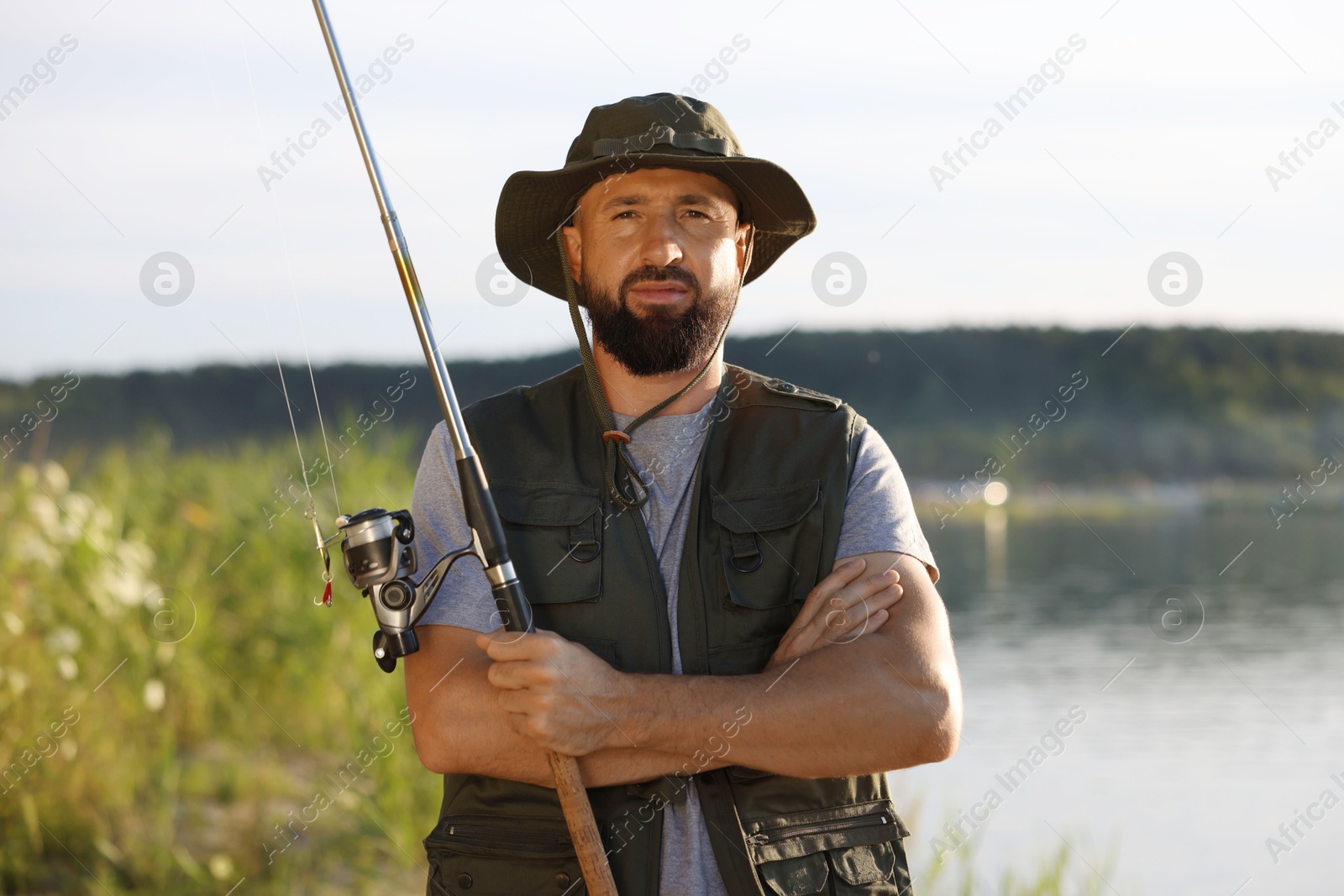Fisherman with rod near lake at summer Photo of Fisherman with rod near lake at summer