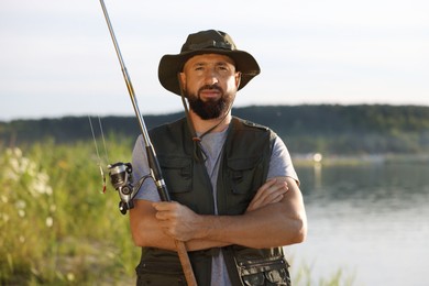 Photo of Fisherman with rod near lake at summer