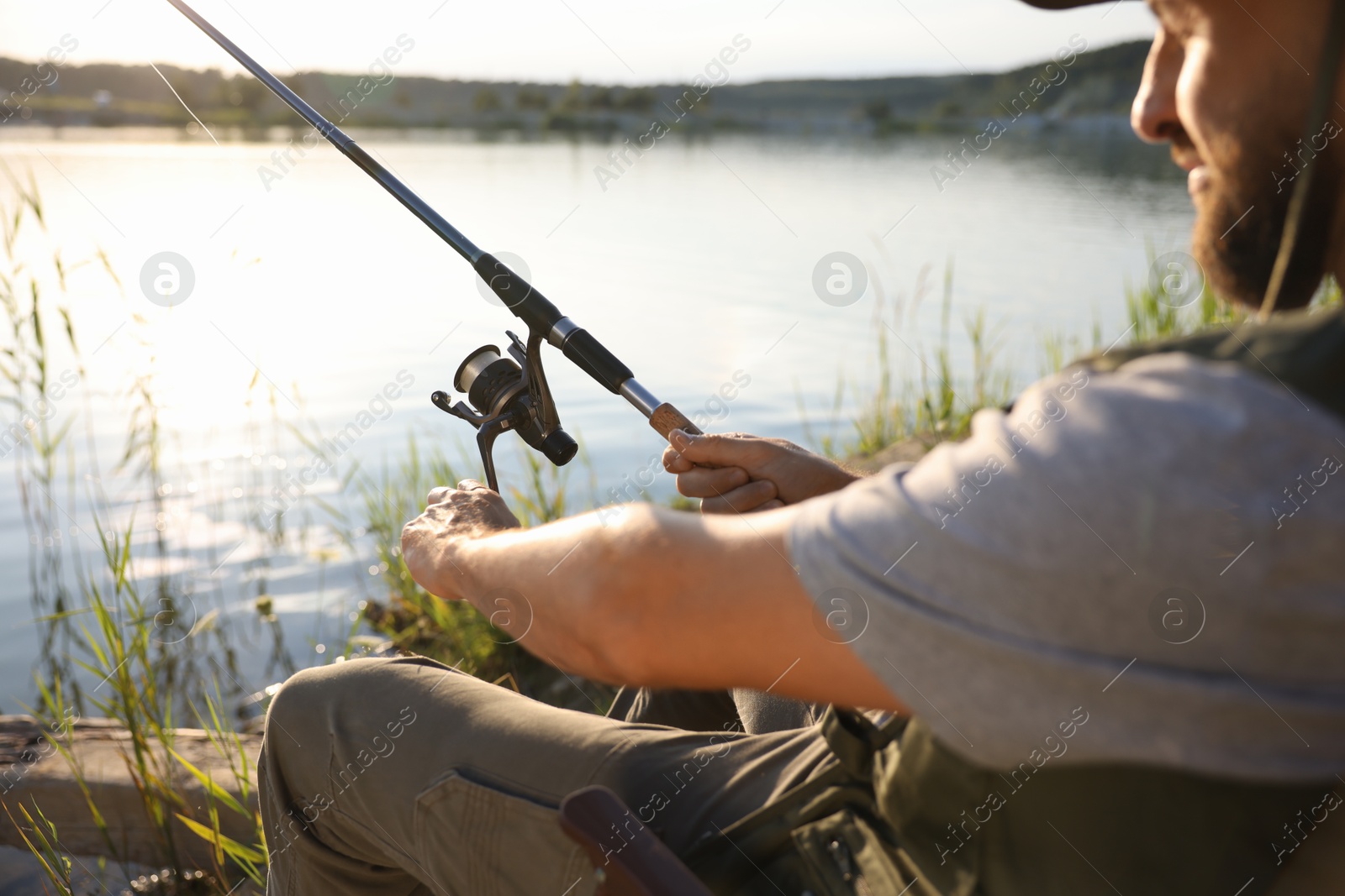Fisherman with rod fishing near lake at summer, selective focus Photo of Fisherman with rod fishing near lake at summer, selective focus