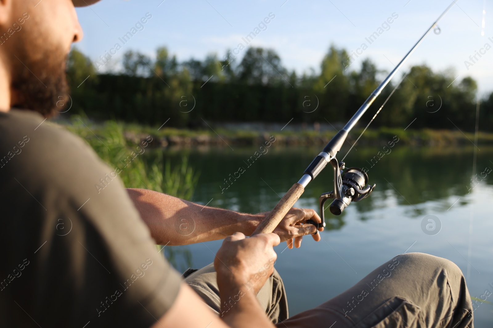 Fisherman with rod fishing near lake at summer, closeup Photo of Fisherman with rod fishing near lake at summer, closeup