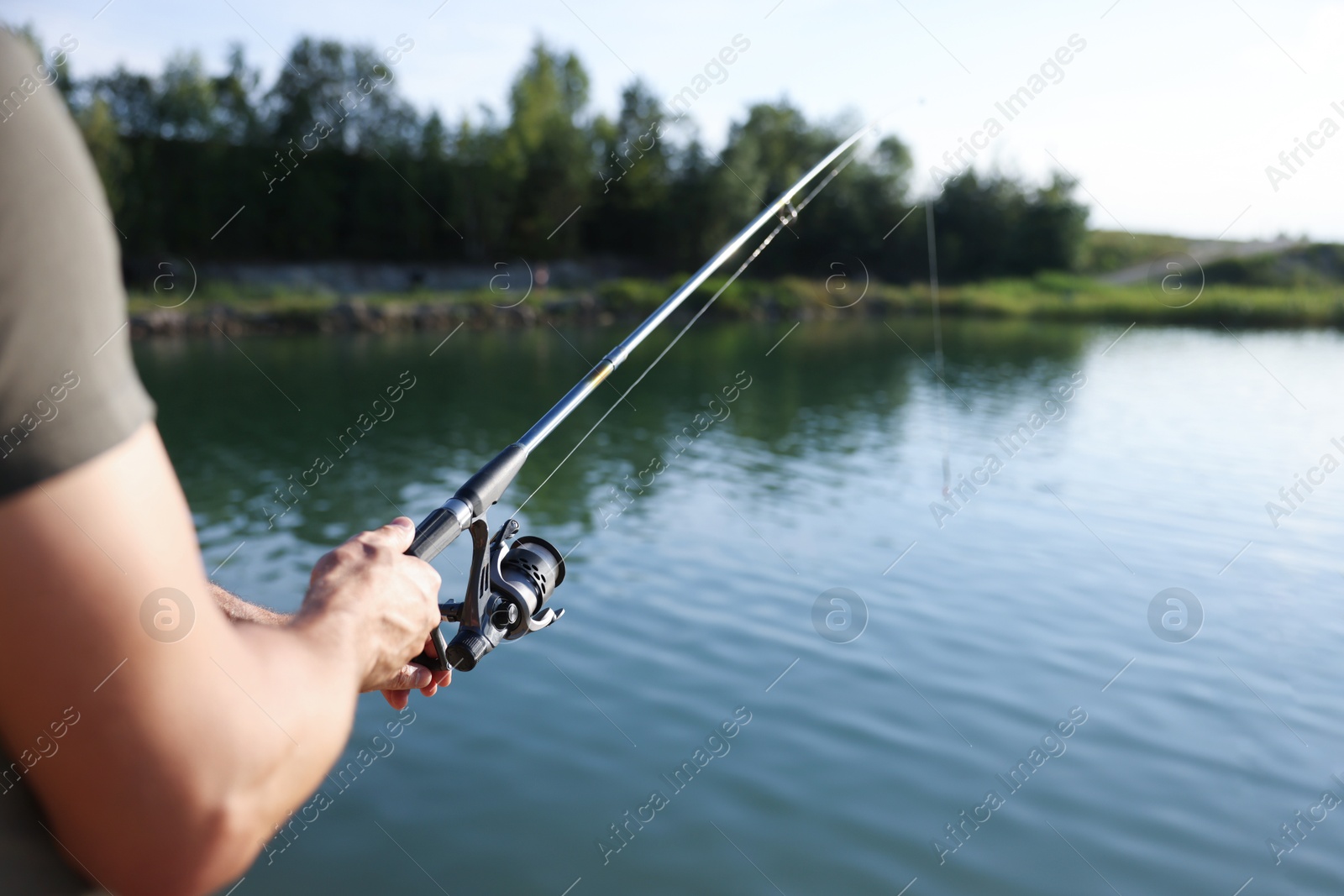 Fisherman with rod fishing near lake at summer, closeup Photo of Fisherman with rod fishing near lake at summer, closeup