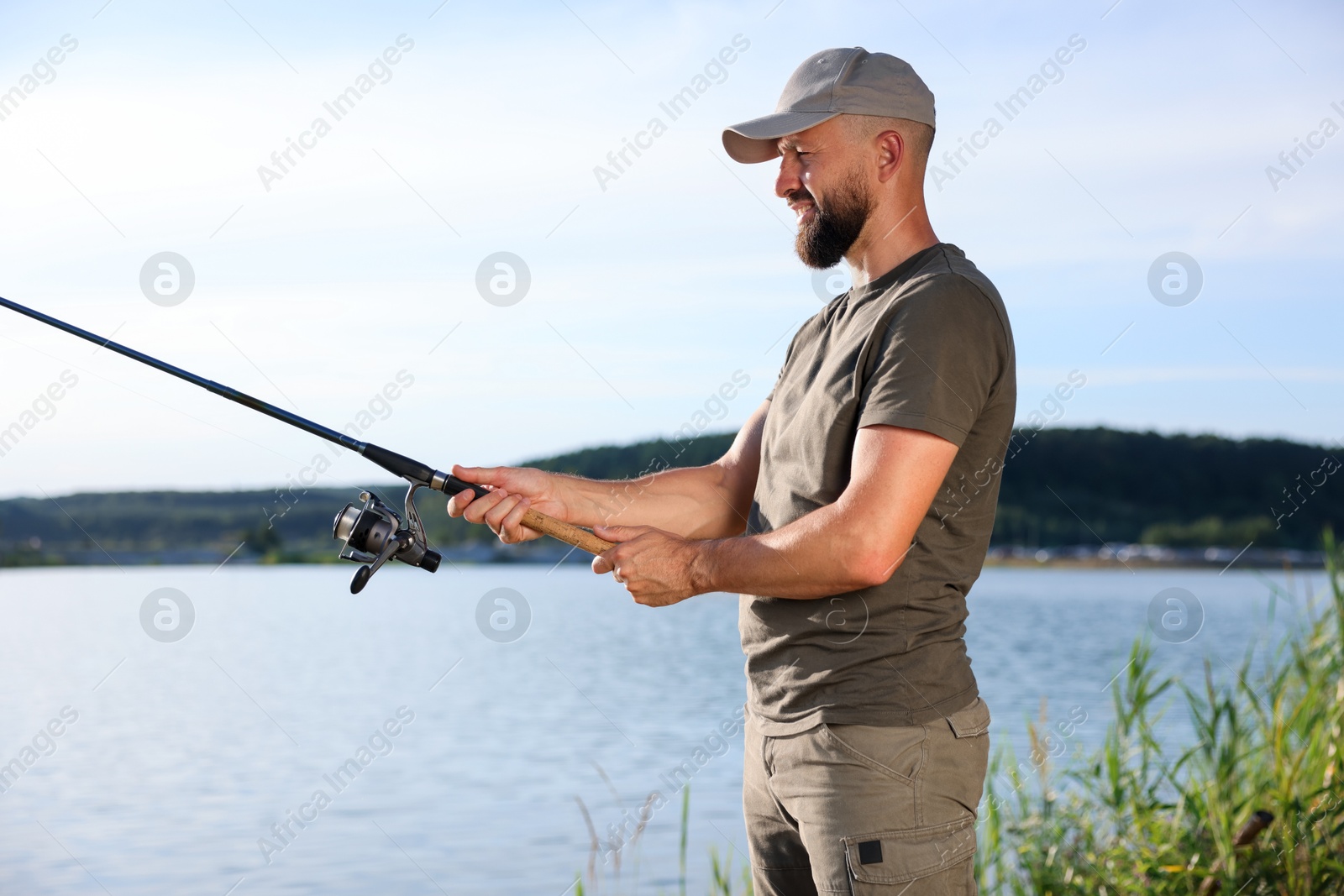 Fisherman with rod fishing near lake at summer Photo of Fisherman with rod fishing near lake at summer