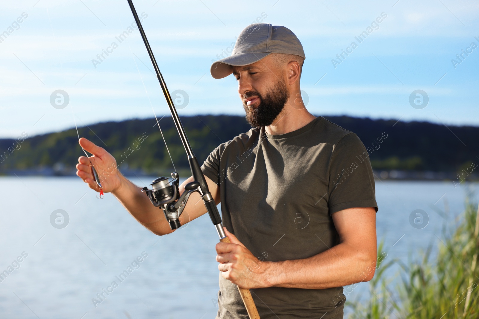Fisherman with rod near lake at summer Photo of Fisherman with rod near lake at summer