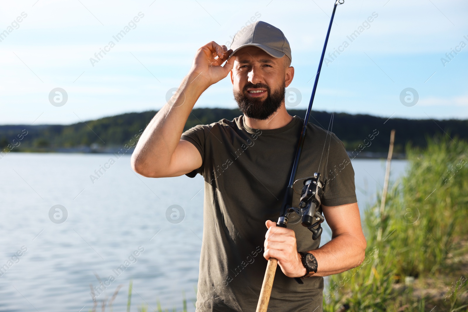 Fisherman with rod near lake at summer Photo of Fisherman with rod near lake at summer