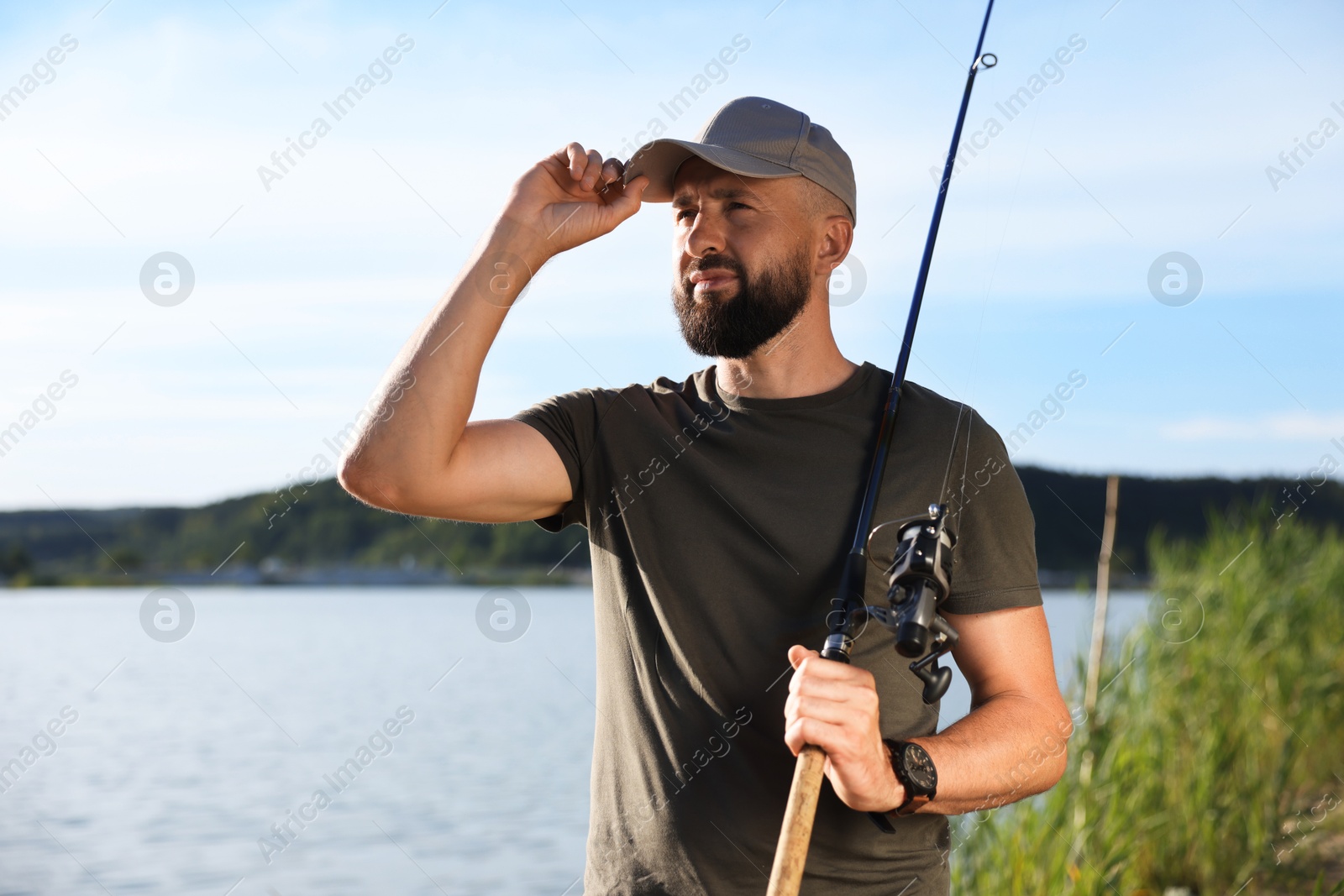 Fisherman with rod near lake at summer Photo of Fisherman with rod near lake at summer