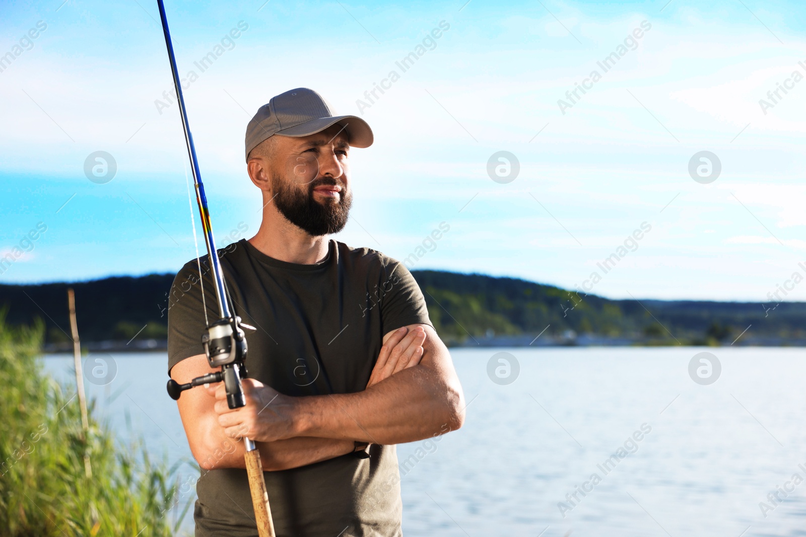 Fisherman with rod near lake at summer. Space for text Photo of Fisherman with rod near lake at summer. Space for text