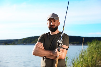 Photo of Fisherman with rod near lake at summer