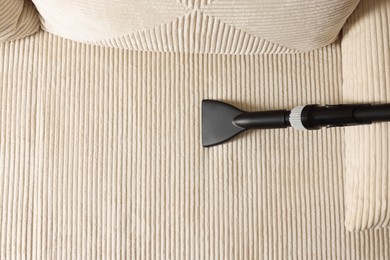 Photo of One vacuum cleaner nozzle on sofa, top view. Space for text