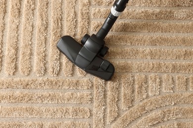 Photo of One vacuum cleaner nozzle on carpet, top view