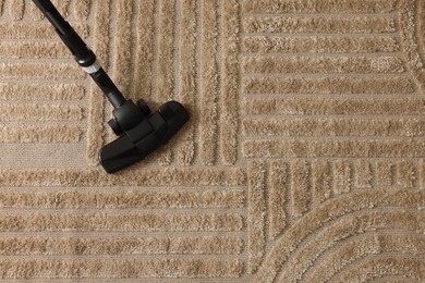 Photo of One vacuum cleaner nozzle on carpet, top view. Space for text