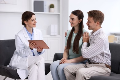 Photo of In vitro fertilization (IVF). Happy couple having appointment with doctor in reproductive clinic