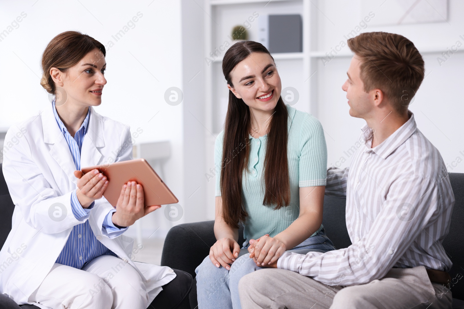 In vitro fertilization (IVF). Happy couple having appointment with doctor in reproductive clinic Photo of In vitro fertilization (IVF). Happy couple having appointment with doctor in reproductive clinic