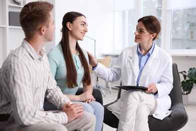 Photo of In vitro fertilization (IVF). Doctor encouraging couple during visit in reproductive clinic