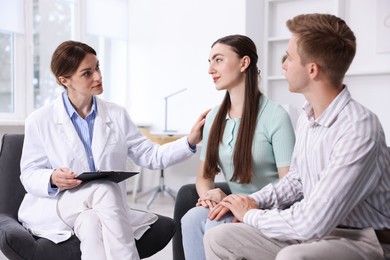 Photo of In vitro fertilization (IVF). Doctor encouraging couple during visit in reproductive clinic