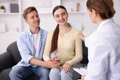 Photo of In vitro fertilization (IVF). Doctor encouraging couple during visit in reproductive clinic