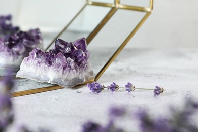 Photo of Aura. Beautiful amethyst and lavender on white textured table, closeup