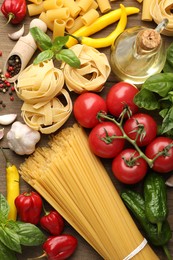 Photo of Different types of raw pasta and products on wooden table, flat lay
