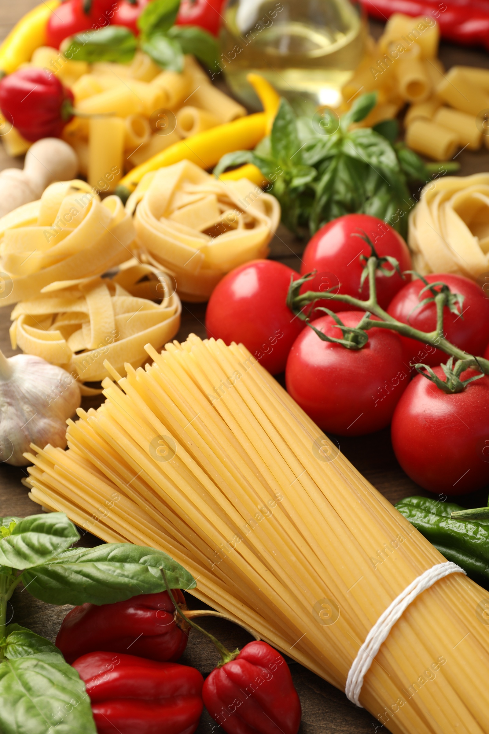 Photo of Different types of raw pasta and products on table, closeup