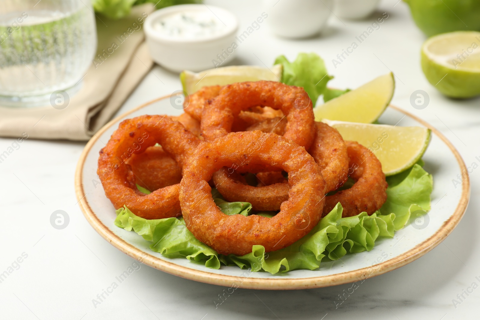 Fried squid rings served on white marble table, closeup Photo of Fried squid rings served on white marble table, closeup