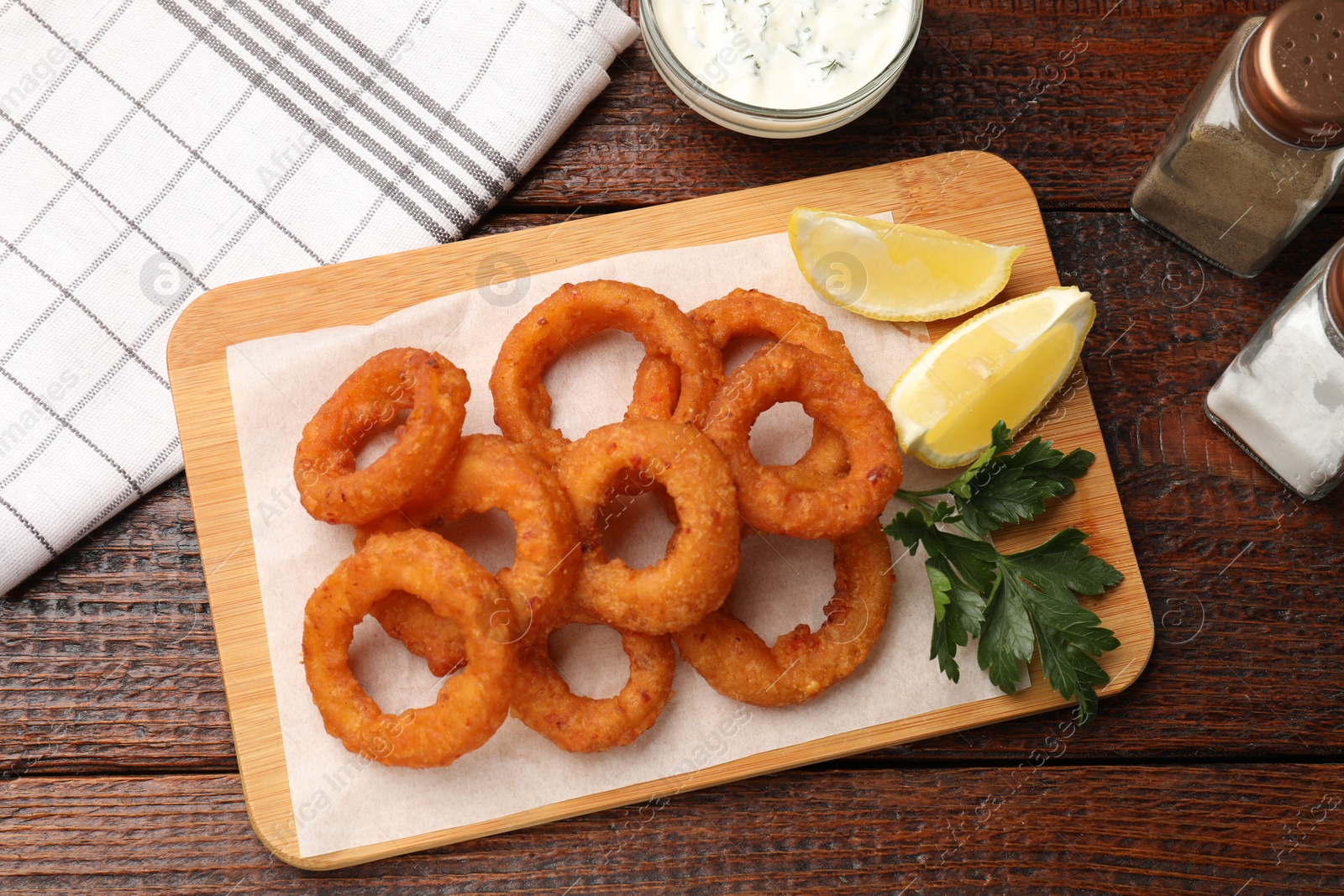 Fried squid rings served on wooden table, flat lay Photo of Fried squid rings served on wooden table, flat lay