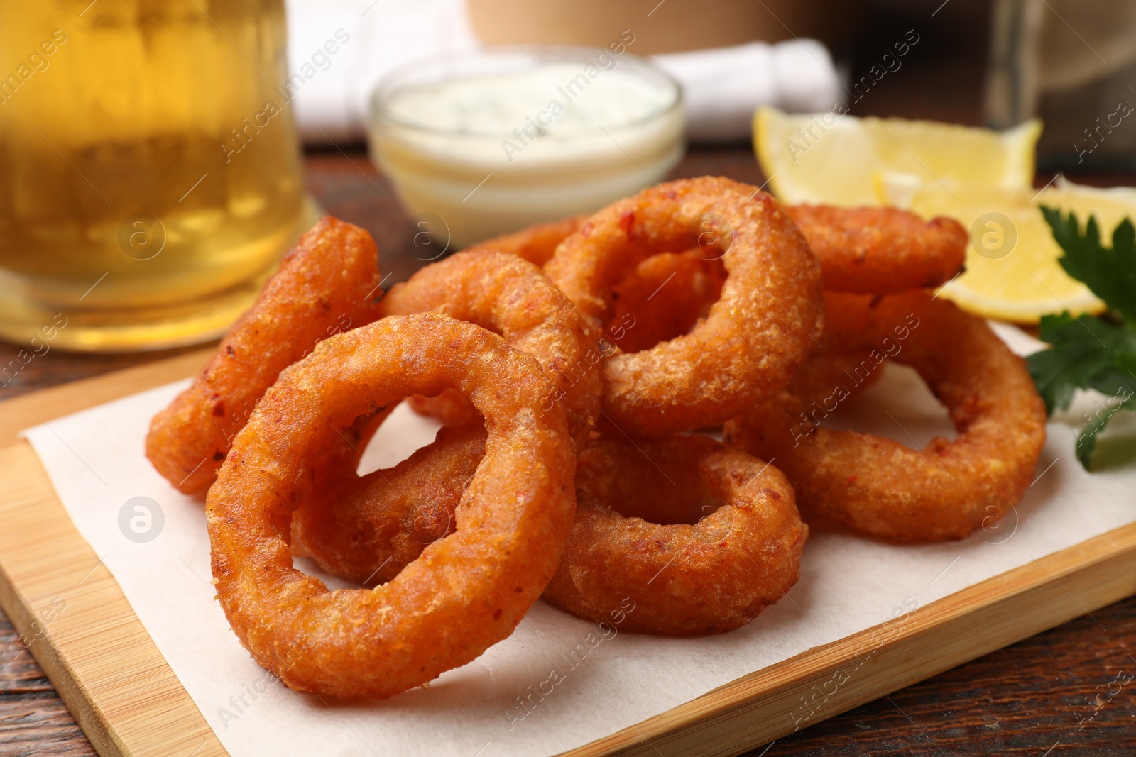 Fried squid rings served on wooden table, closeup Photo of Fried squid rings served on wooden table, closeup