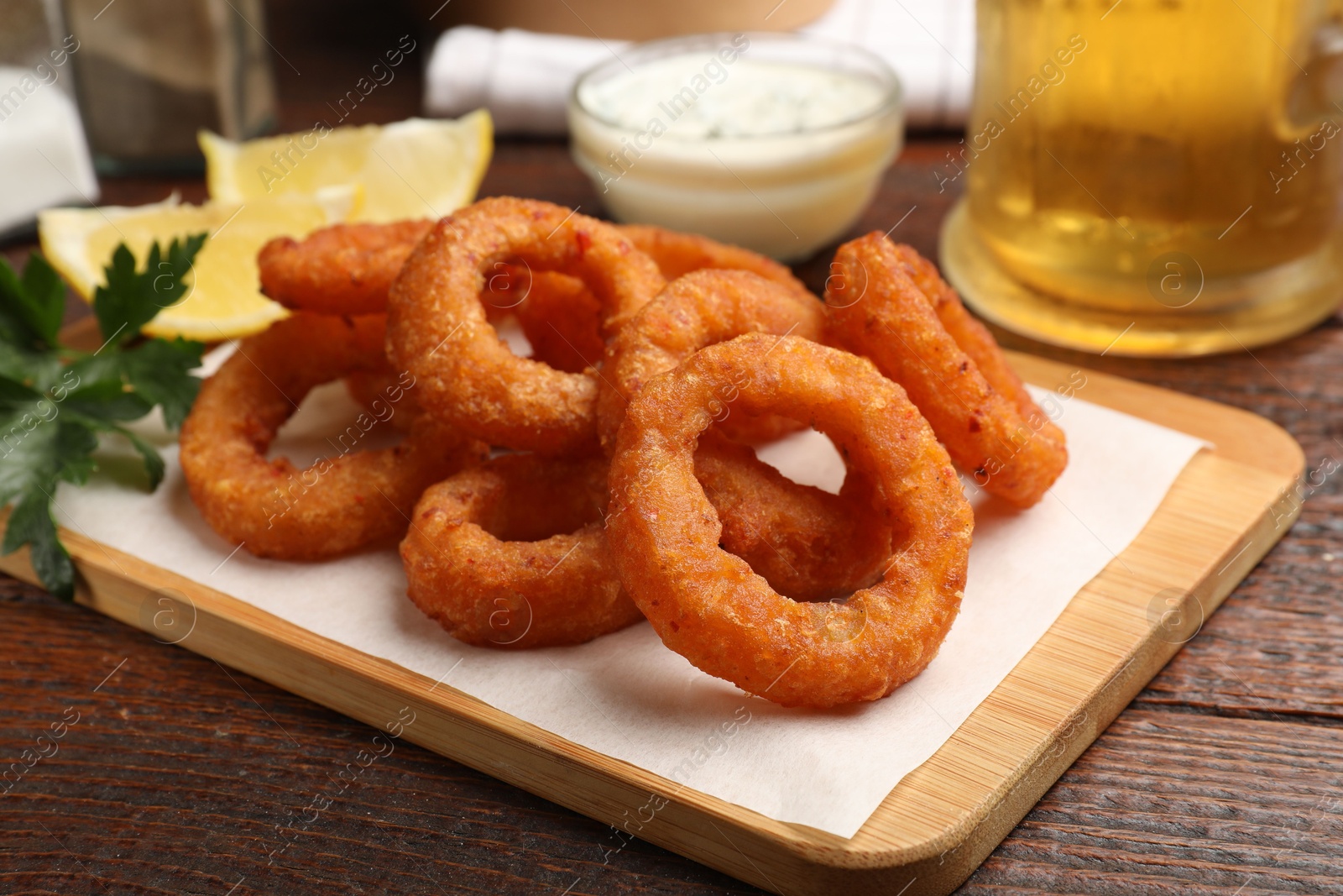Fried squid rings served on wooden table, closeup Photo of Fried squid rings served on wooden table, closeup