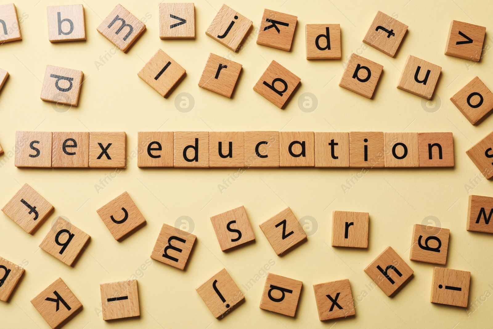 Photo of Words Sex Education made of wooden squares with letters on beige background, flat lay