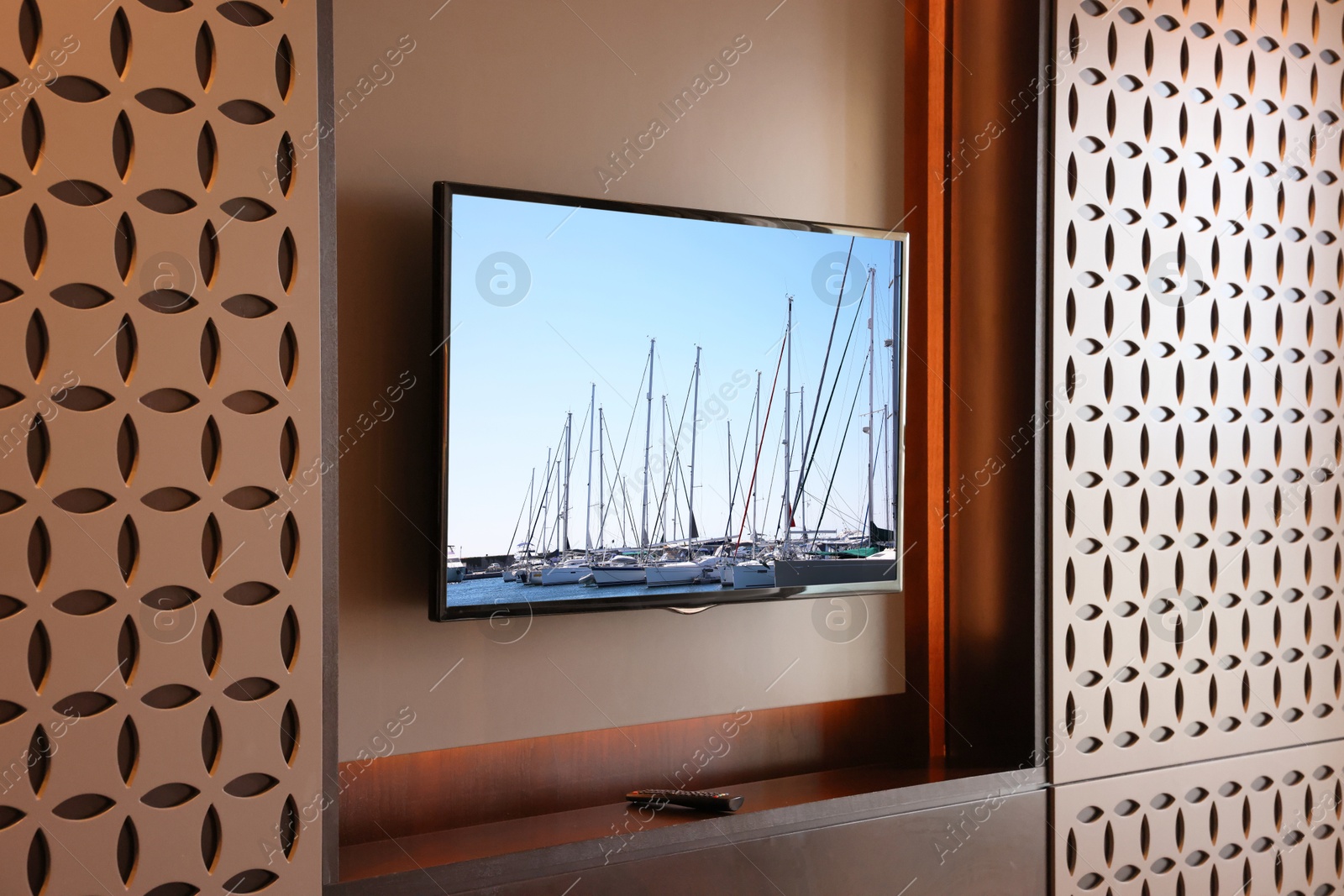 Image of TV set with boats near pier on screen in room