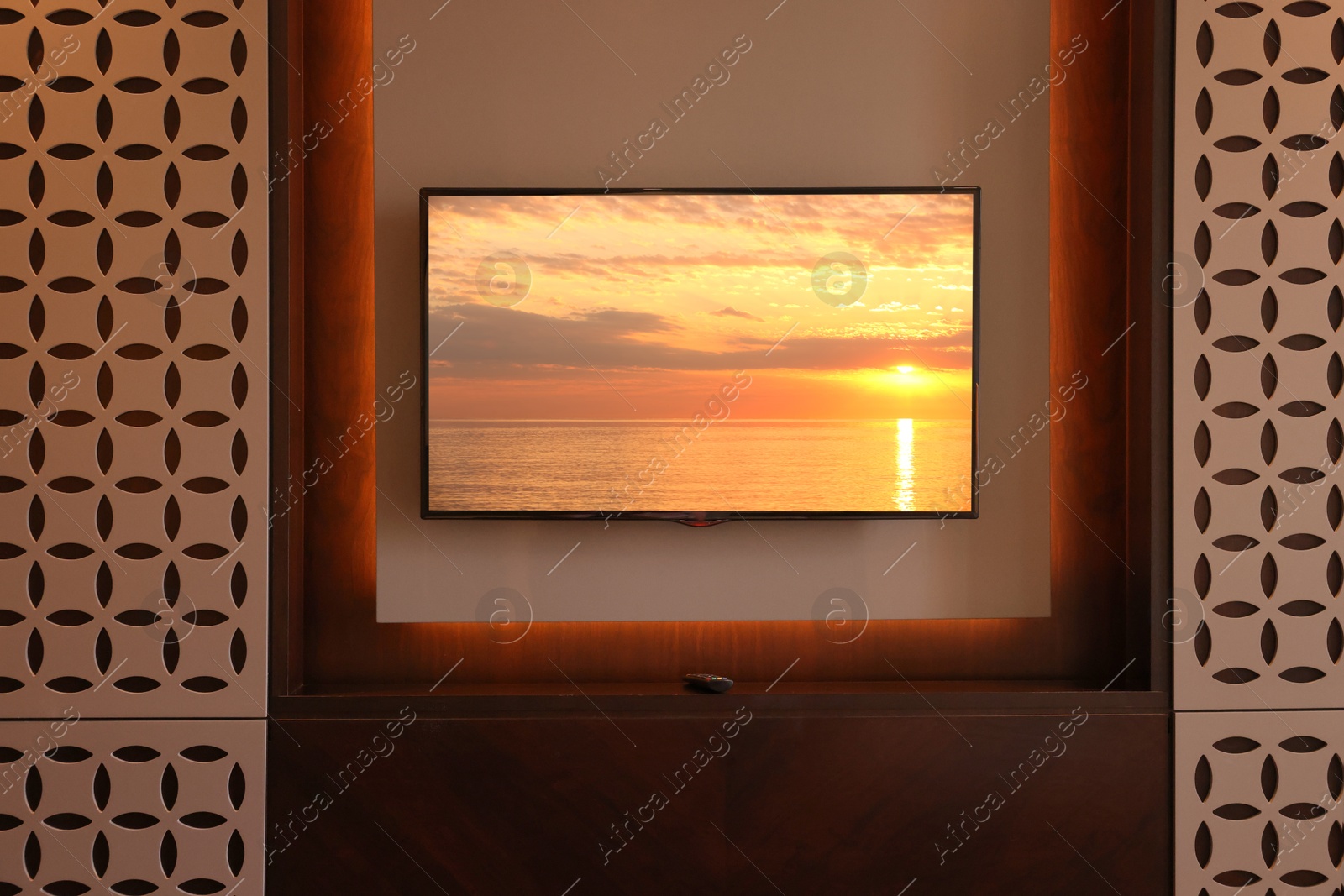 Image of TV set with sunset seascape on screen in room