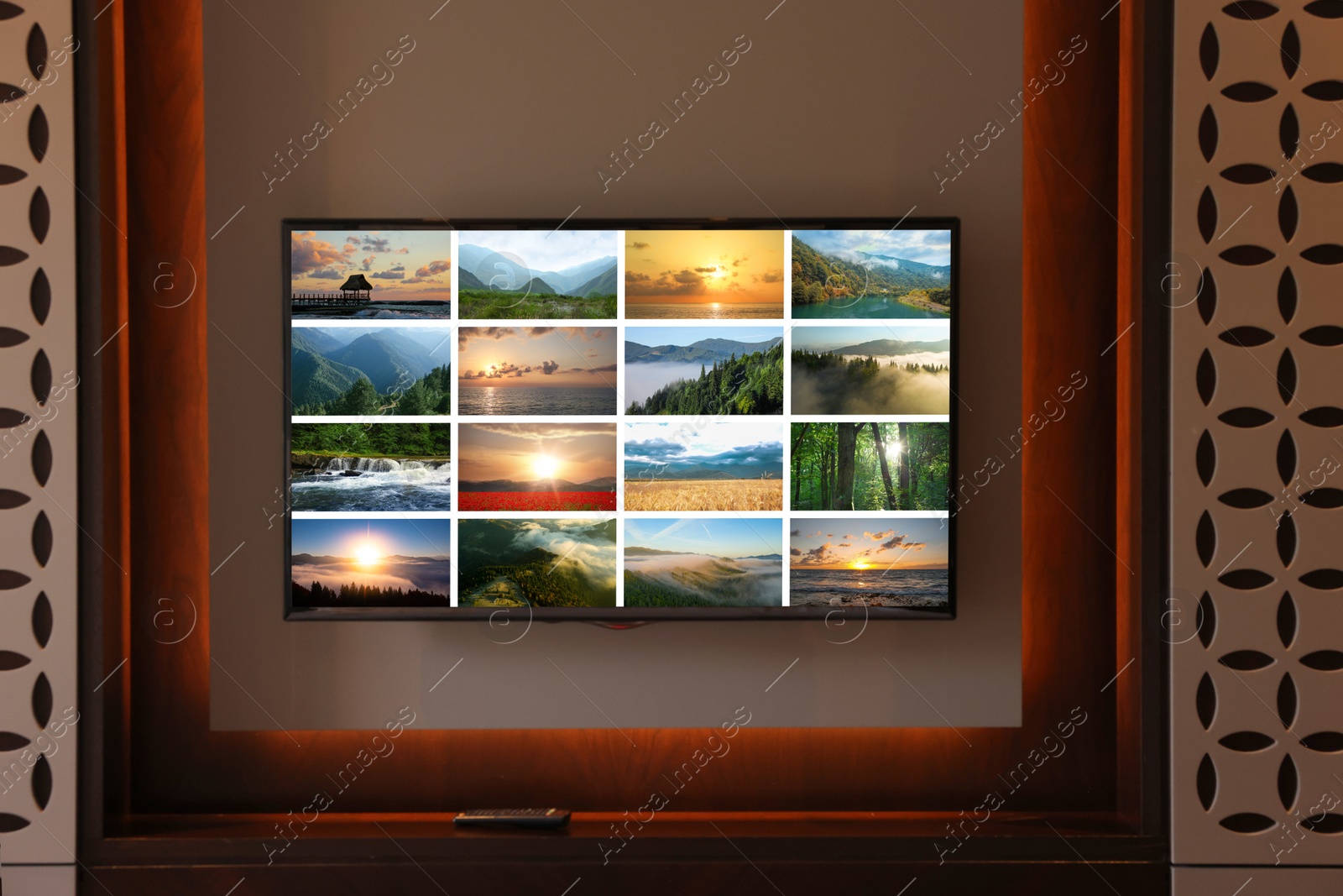 Image of TV set mounted on wall in room. Collage of landscapes on screen