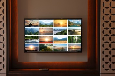 Image of TV set mounted on wall in room. Collage of landscapes on screen