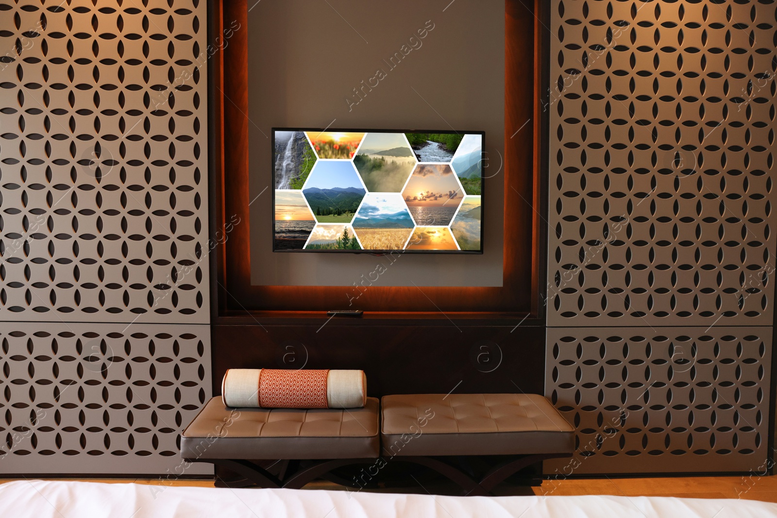 Image of TV set mounted on wall in room. Collage of landscapes on screen