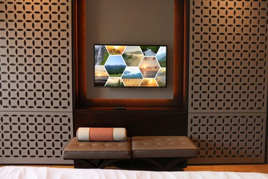 Image of TV set mounted on wall in room. Collage of landscapes on screen