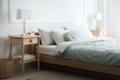 Photo of Bedside tables with lamps near bed indoors