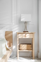 Photo of Bedside table with lamp near bed indoors