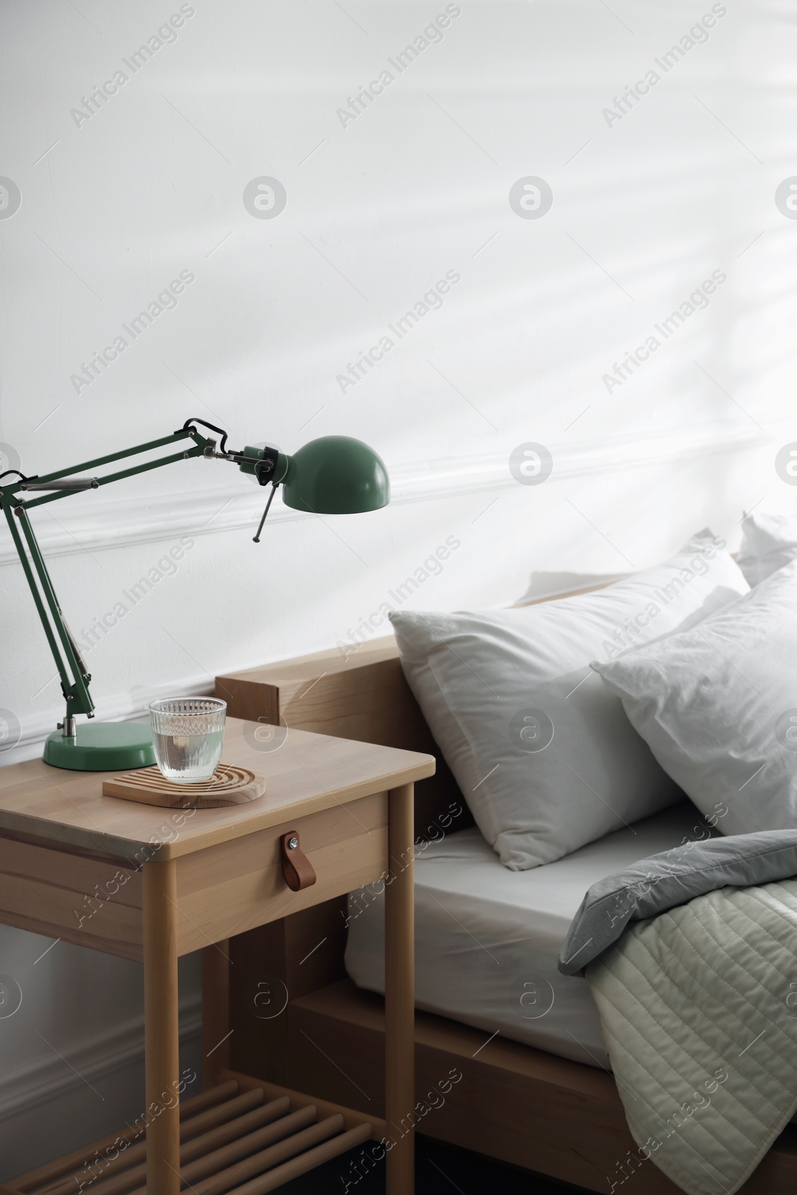 Photo of Bedside table with decor near bed indoors