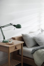 Photo of Bedside table with decor near bed indoors