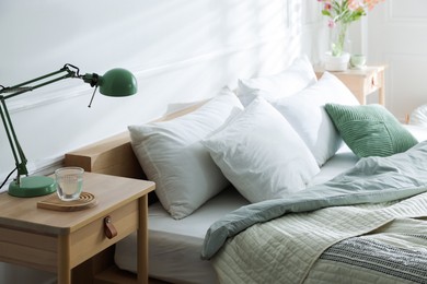 Photo of Bedside tables with decor near bed indoors