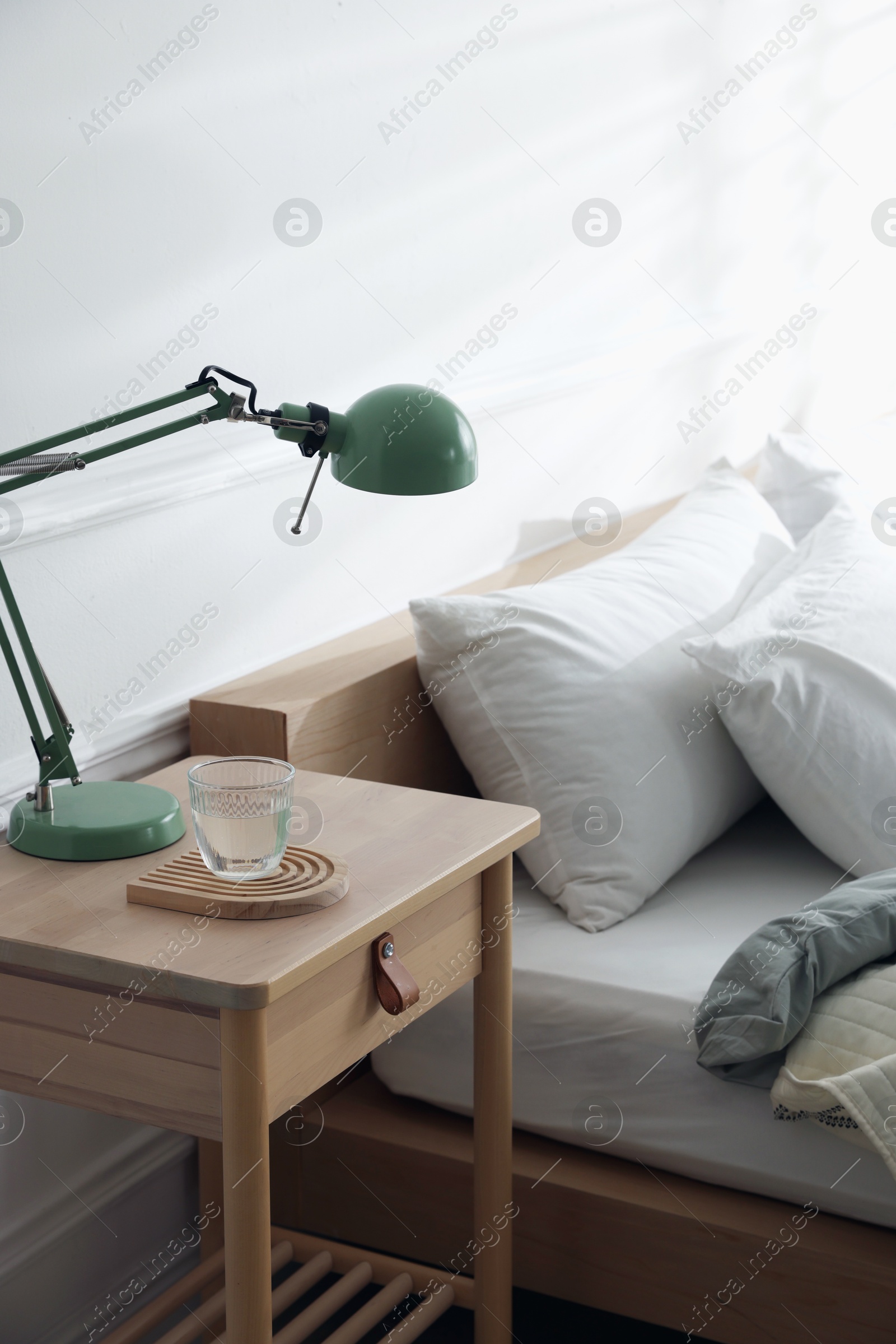 Photo of Bedside table with decor near bed indoors