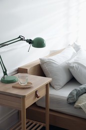 Photo of Bedside table with decor near bed indoors