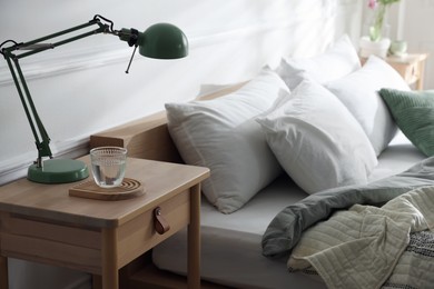 Photo of Bedside tables with decor near bed indoors
