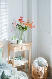 Photo of Bedside table with different decor near bed indoors